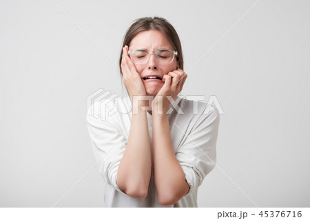 Woman in modern glasses covering ears 45376716