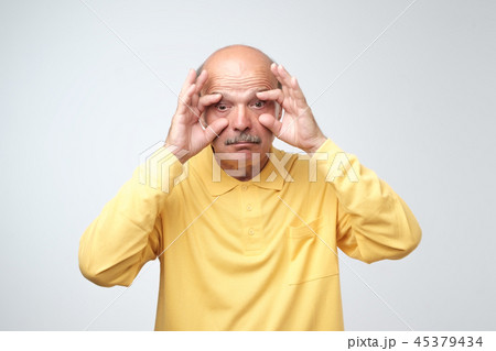 senior man trying to open his eyes with fingers. 45379434