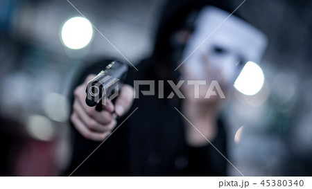 Mystery hoodie man in white mask pointing gun 45380340
