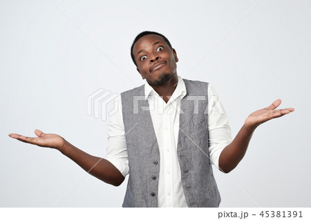 african man shrugs shoulders with confusion 45381391