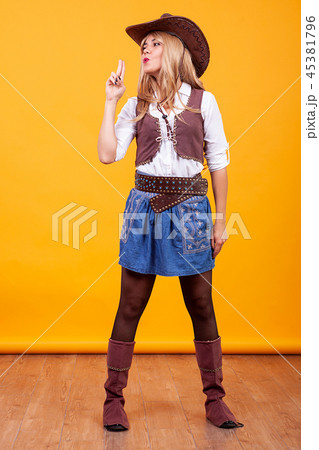 Beautiful young woman wearing cowboy costume over yellow background Beautiful young woman wearing cowboy costume over yellow background 45381796