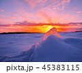 Transparent piece of ice on the snow against the backdrop of a winter sunset 45383115