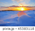 Transparent piece of ice on the snow against the backdrop of a winter sunset 45383118