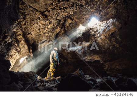 Man standing under the light in the mountain cave. 45384246