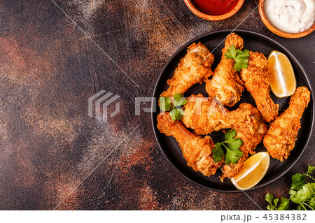 Fried chicken legs with lemon and parsley. Fried chicken legs with lemon and parsley. 45384382