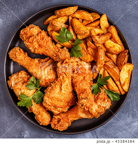 Fried chicken legs with potatoes. 45384384