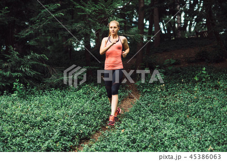 Caucasian woman running on forest trail  45386063