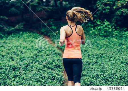 Caucasian woman running on forest trail  45386064