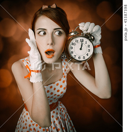 Beautiful redhead woman with clock. 45387398