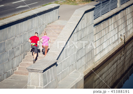 Photo from back of sporting man and woman running up stairs Photo from back of sporting man and woman running up stairs 45388191
