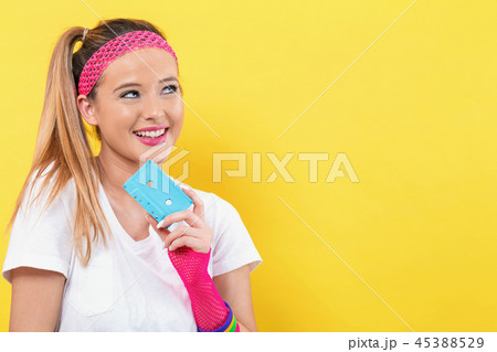 Woman in 1980's fashion holding a cassette tape 45388529