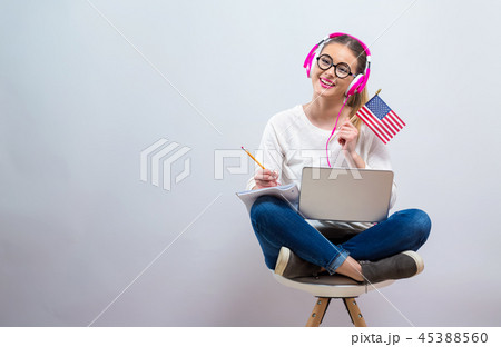 Young woman with USA flag using a laptop computer Young woman with USA flag using a laptop computer 45388560