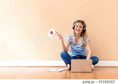 Young woman with Japanese flag using a laptop computer Young woman with Japanese flag using a laptop computer 45388567