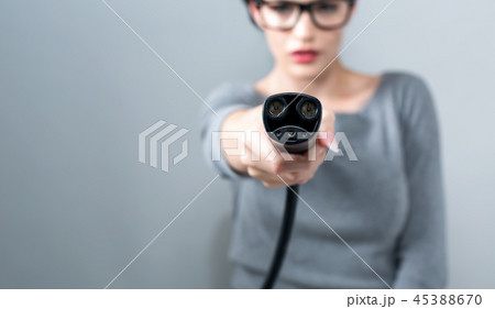 Young woman with an electric vehicle charger 45388670
