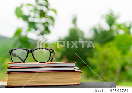 Books and eyeglasses with nature background. Books and eyeglasses with nature background. 45397781