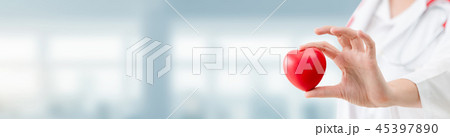Doctor holding a red heart at hospital office. 45397890