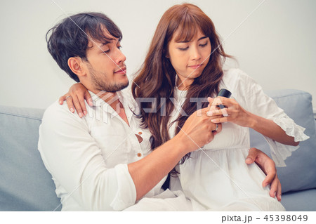 Couple fight fot TV remote in living room. Couple fight fot TV remote in living room. 45398049