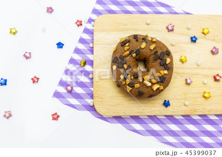 Donut on wood plate with pattern napery  45399037
