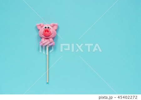 Funny pink pig lollipop on blue background. Funny pink pig lollipop on blue background. 45402272
