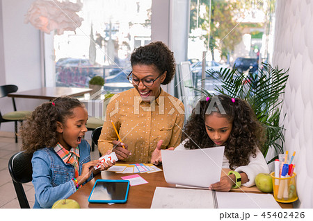 Curly dark-haired nursery teacher feeling happy after success of girl 45402426