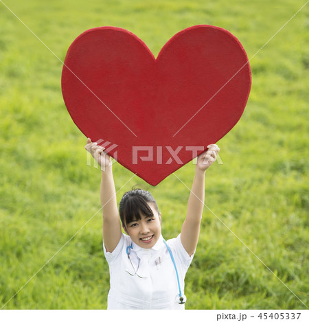 草原でハートを掲げる看護師 45405337