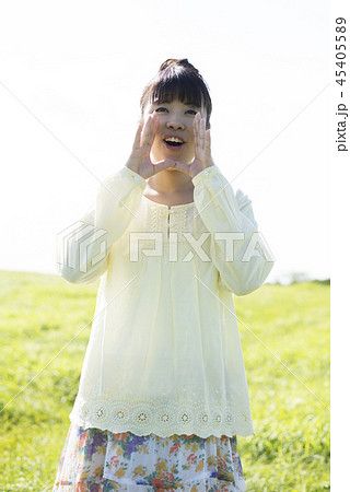 草原で口元に手をあてる女性 45405589