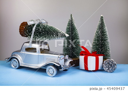 Silver retro car with a tree on the roof. Silver retro car with a tree on the roof. 45409437