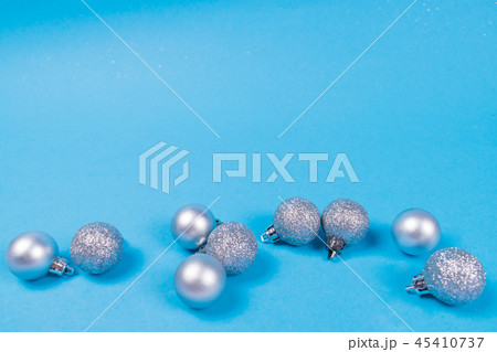 Many silver baubles on blue background. 45410737