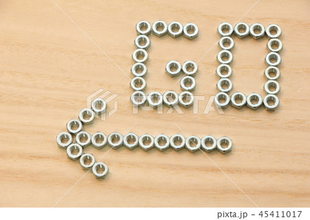 六角ナットで木の板の上に書かれた「GO」の文字と矢印。 六角ナットで木の板の上に書かれた「GO」の文字と矢印。 45411017