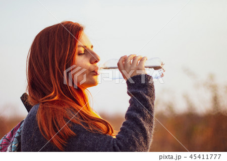Young redhead girl drinks water Young redhead girl drinks water 45411777