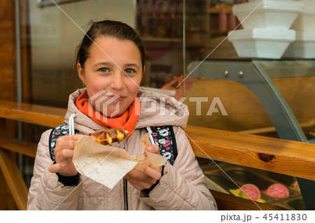 The girl eats a waffle The girl eats a waffle 45411830