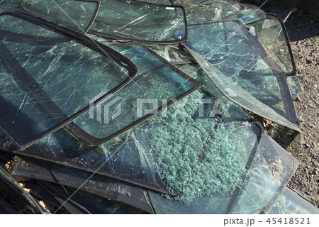 Pile of cracked car windshields on the ground 45418521