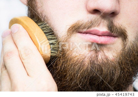 Hand of barber brushing beard. Hand of barber brushing beard. 45419743