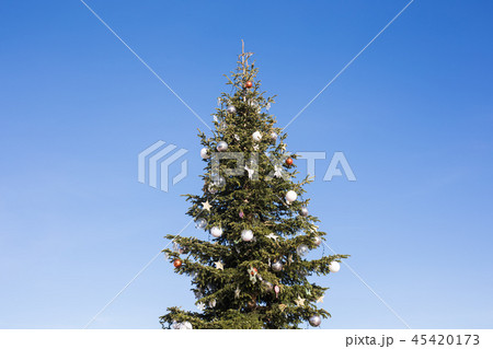 Big festive Christmas tree against blue sky 45420173