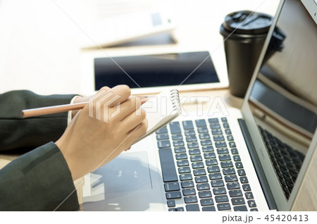 真面目に仕事する20代のOL。パソコン・タブレット・スマホ・書類・パスポート。真剣に考える。悩む。 45420413