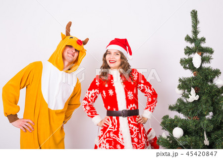 People, family and christmas concept - young couple in santa and deer costumes over white background 45420847