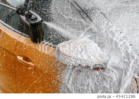 Detail on yellow car side mirror covered shampoo 45421286