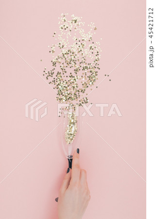 Champagne glass poured out golden stars confetti 45421712