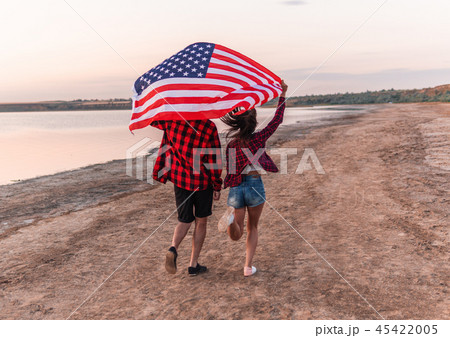 oung couple on the beach walking together 45422005