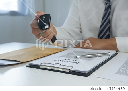 hand hand giving a car key, document on table hand hand giving a car key, document on table 45424980