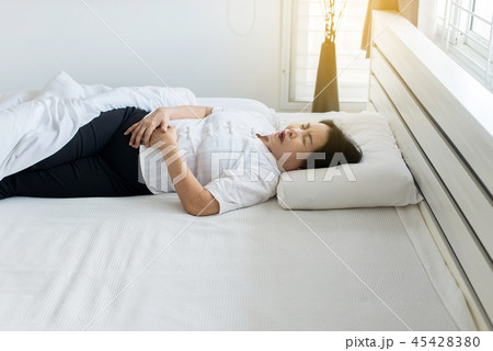 Elderly asian woman having painful stomachache  45428380