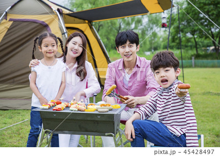Family having picnic outdoors. Parents with two children relax in the park. Concept of happy family relations and carefree leisure time. 278 45428497