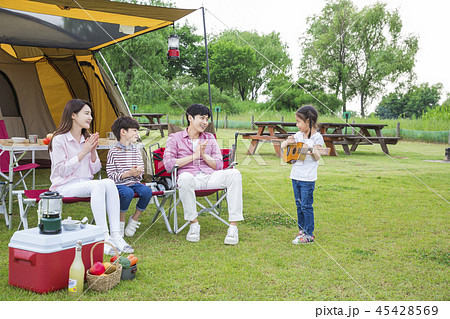 Family having picnic outdoors. Parents with two children relax in the park. Concept of happy family relations and carefree leisure time. 224 45428569