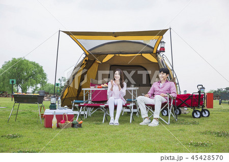 Family having picnic outdoors. Parents with two children relax in the park. Concept of happy family relations and carefree leisure time. 216 45428570