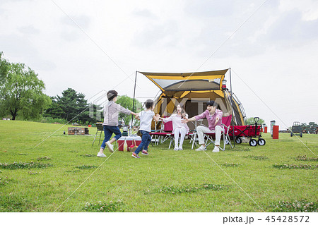 Family having picnic outdoors. Parents with two children relax in the park. Concept of happy family relations and carefree leisure time. 221 45428572