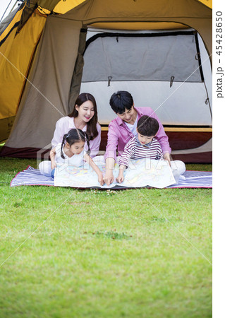 Family having picnic outdoors. Parents with two children relax in the park. Concept of happy family relations and carefree leisure time. 215 Family having picnic outdoors. Parents with two children relax in the park. Concept of happy family relations and carefree leisure time. 215 45428650
