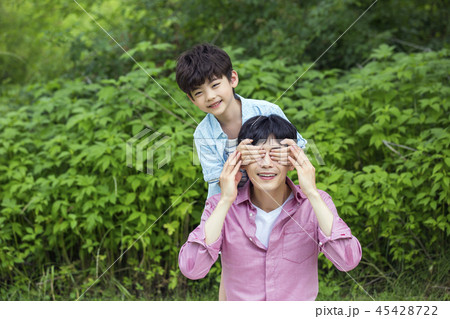 Family having picnic outdoors. Parents with two children relax in the park. Concept of happy family relations and carefree leisure time. 121 45428722