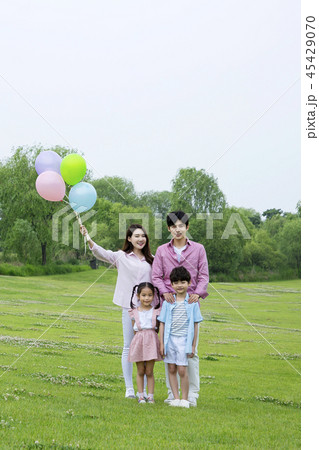 Family having picnic outdoors. Parents with two children relax in the park. Concept of happy family relations and carefree leisure time. 026 Family having picnic outdoors. Parents with two children relax in the park. Concept of happy family relations and carefree leisure time. 026 45429070