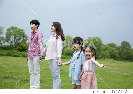 Family having picnic outdoors. Parents with two children relax in the park. Concept of happy family relations and carefree leisure time. 009 45429420