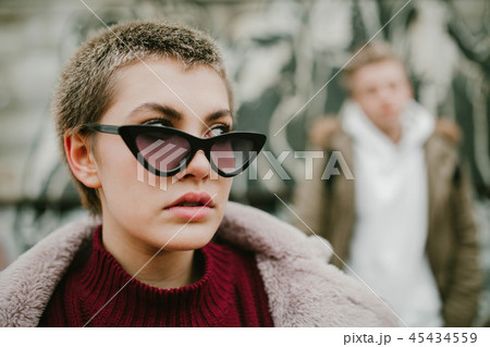 Girl with short hair in black sunglasses on the street 45434559